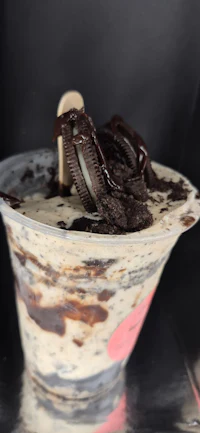 a cup of ice cream with chocolate and oreos